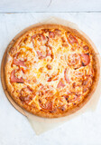Pizza with mozzarella cheese, ham, tomatoes and sauce on plain grey background