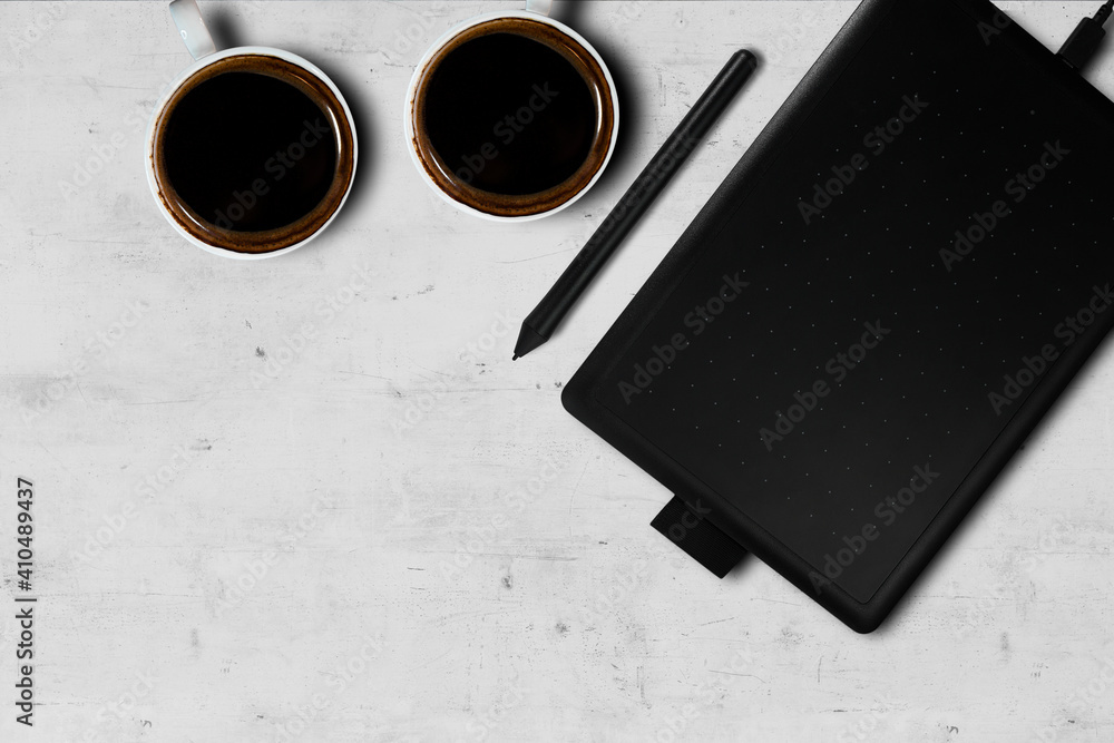 Minimal workspace graphic tablet with coffee cup. copy space on a gray stone table background. Top view. Flat lay style.