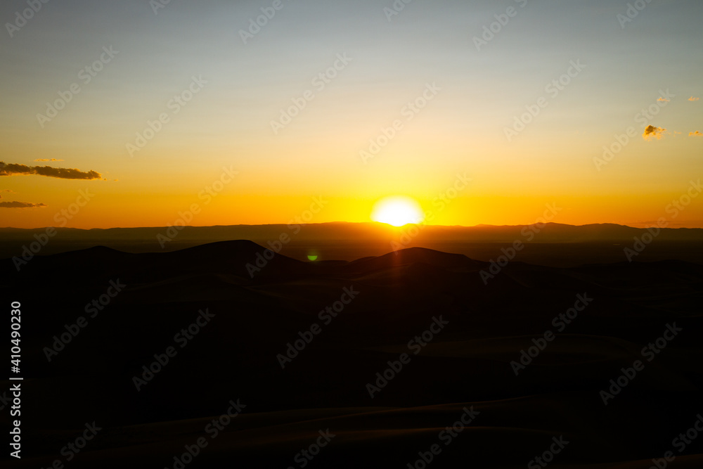 Orange horizon sunset over sandy dunes in great sand dunes national park in ameika