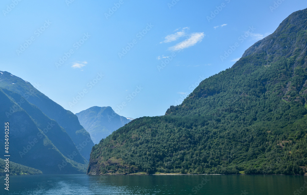 The clear waters of and green hills at sunny day. Boat trip through the largest and one of the most beautiful fjords in Norway Sognefjord