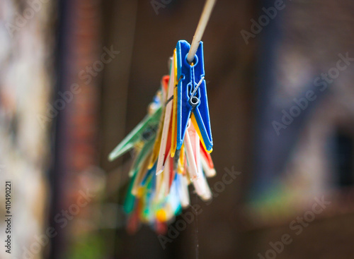 Colorful clothespin clothespins on the hangers. Plastic clothespins in different colors on the background of a brick, antique wall . photo