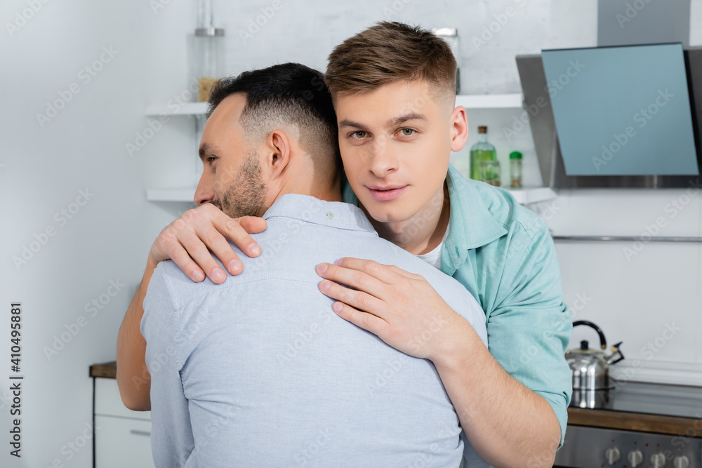 homosexual man calming and hugging worried husband at home - obrazy, fototapety, plakaty 