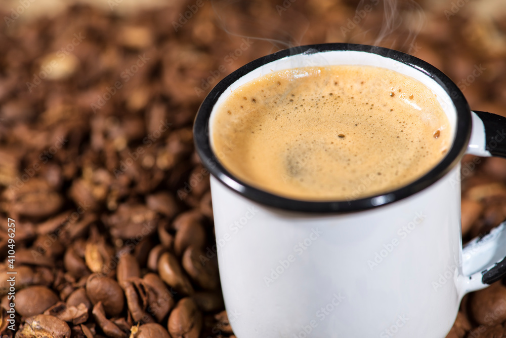 Cup of coffee on wooden table with coffee beans Cup of coffee on wooden table with coffee beans