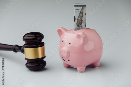 Judge wooden gavel and piggy bank with dollar bill. Loan and finance concept. photo