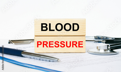 Wooden blocks with text Blood Pressure on a clipboard  stethoscope and pen