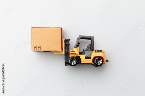 Mini model of forklift with carton box isolated on white background. Logistics and delivery concept. Top view.