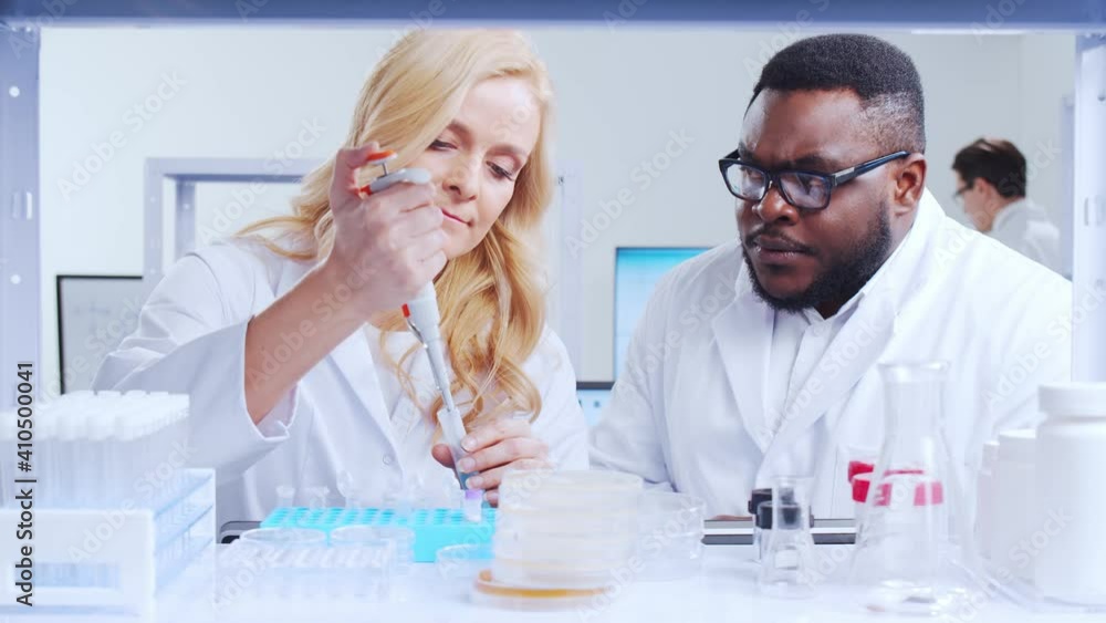 Professional team of scientists is working on a vaccine in a modern scientific research laboratory. Genetic engineer workplace. Futuristic technology and science concept. Professional team of scientists is working on a vaccine in a modern scientific research laboratory. Genetic engineer workplace. Futuristic technology and science concept.