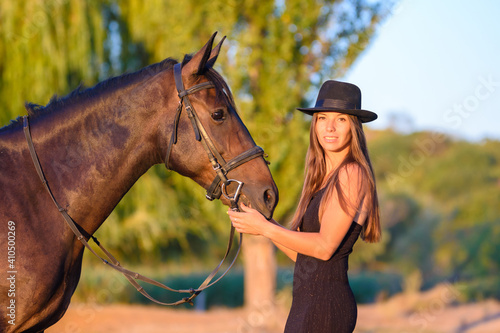 The girl stands in front of the horse and turned and looked into the frame