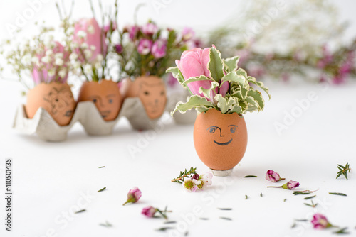 Flower growing inside egg cover with smiley