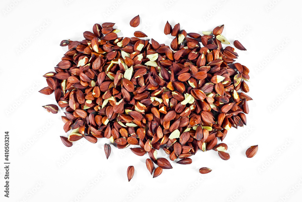 Obraz premium Texture of beech nuts on a white background. Lots of peeled nuts on a pile close up.