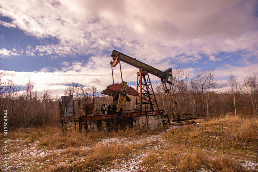 Old abandoned oil pump in the middle of the forest