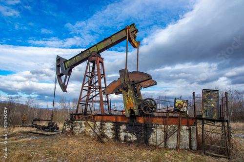Old abandoned oil pump in the middle of the forest