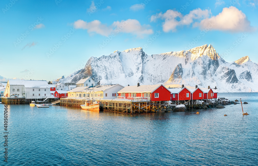 Traditional Norwegian red wooden houses (rorbuer) on the shore of  Reinefjorden near Hamnoy village.