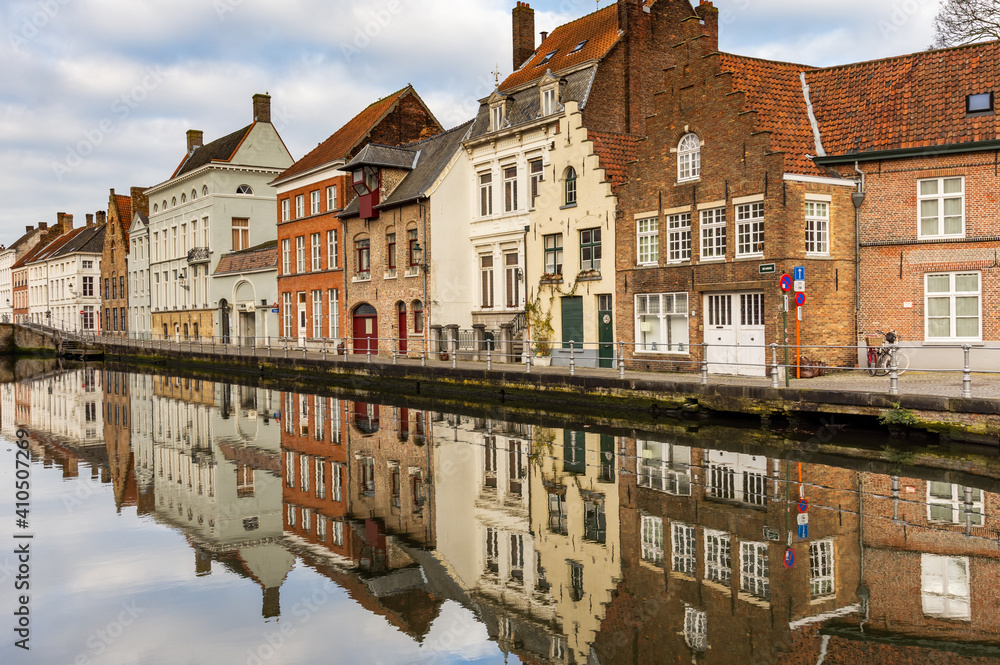 Reflections of typical Bruges house terrace in the canal