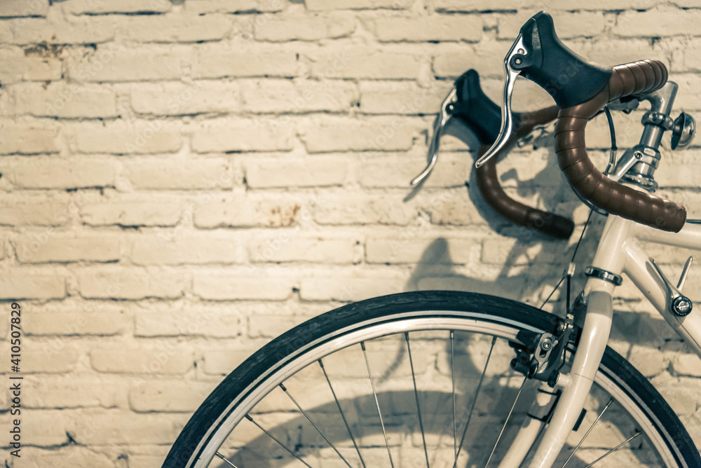Naklejka premium Vintage retro bicycle park at the front of the white wall.