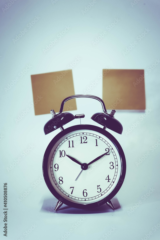 Naklejka premium Vintage retro alarm clock and stack of coins to represent It's time to do money saving for retirement planning as concept.