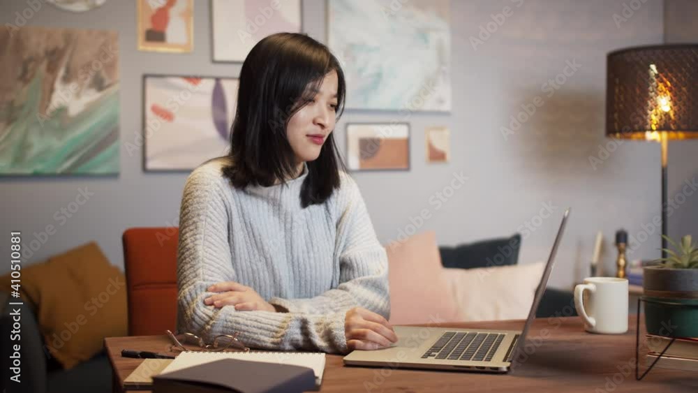 Asian woman using laptop during video conference call. Remote learning during coronavirus lockdown, happy Korean female chat with family and friends home isolation, living room, freelancer home office Asian woman using laptop during video conference call. Remote learning during coronavirus lockdown, happy Korean female chat with family and friends home isolation, living room, freelancer home office