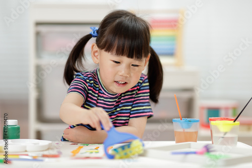 young girl decorating hand made craft for homeschooling