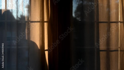 Suspicious person looking in window back lit.