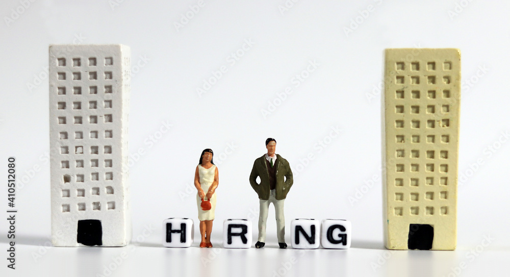 The concept of hiring employees. Miniature people standing between buildings.
The concept of hiring employees. Miniature people standing between buildings.