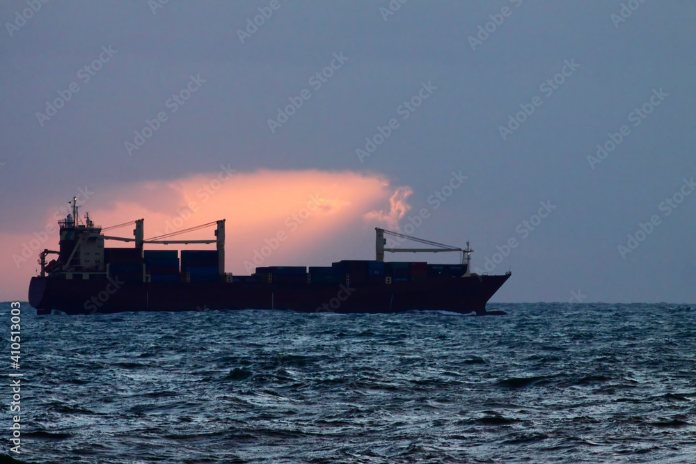 Container ship sailimg at dusk