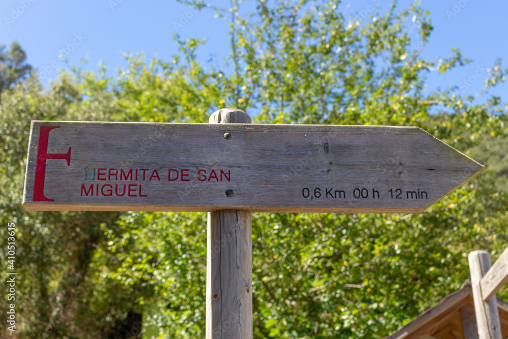 Wooden sign points to San Miguel Hermitage (Ermita de San Miguel) chapel near Santo Toribio de Liebana monastery, Potes, Picos de Europa mountains, Spain.