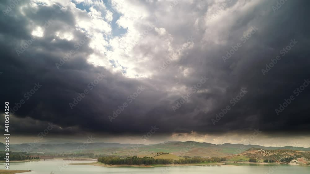 Time lapse of dark clouds moving over spanish hilly landscape and lake Embalse del Guadalhorce, Ardales Reservoir, Malaga Andalusia, Spain. Time lapse of dark clouds moving over spanish hilly landscape and lake Embalse del Guadalhorce, Ardales Reservoir, Malaga Andalusia, Spain.