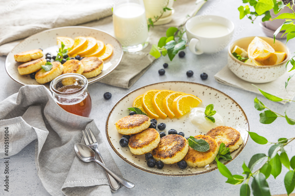 Delicious breakfast with curd fritter,  ricotta fritter or cottage cheese pancakes on ceramic plate. Gourmet healthy delicious morning breakfast. Morning sunny time