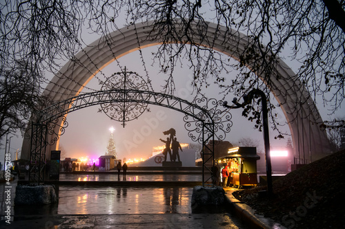 Evening view of the People's Friendship Arch in the park in foggy weather. Kyiv, Ukraine. December 2020 © vlamus