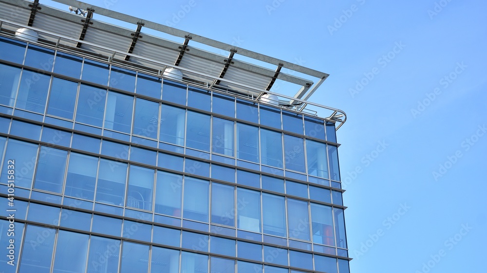 Glass facade of the buildings with a blue sky. Skyscrapers in the business city center.. Background of modern glass buildings. Glass facade of the buildings with a blue sky. Skyscrapers in the business city center.. Background of modern glass buildings.