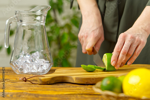 Woman cutting lime in kitchen, lemon water, Refreshing Water with lime and lemon, healthy eating concept