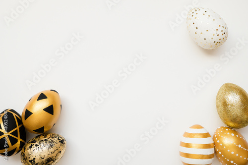 Easter golden decorated eggs isolated on white background. Minimal easter concept. Happy Easter card with copy space for text. Top view, flatlay photo