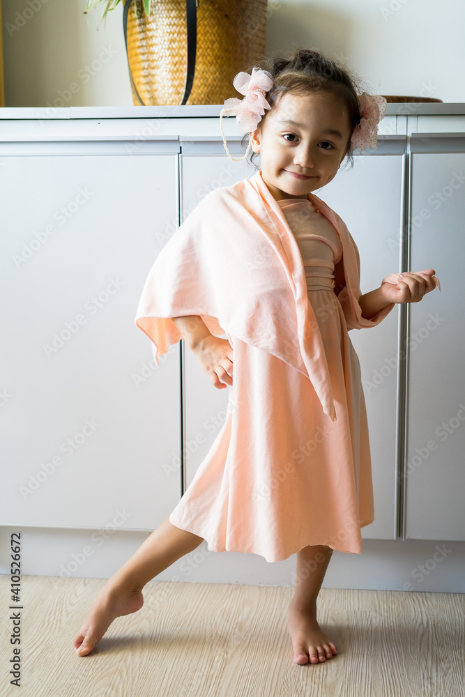 A little girl is standing in a beautiful dress with hair accessories. Pretend play at home. A little girl is standing in a beautiful dress with hair accessories. Pretend play at home.