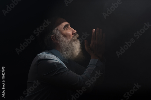 Billede på lærred A senior man standing in dark smoky background light ray from above