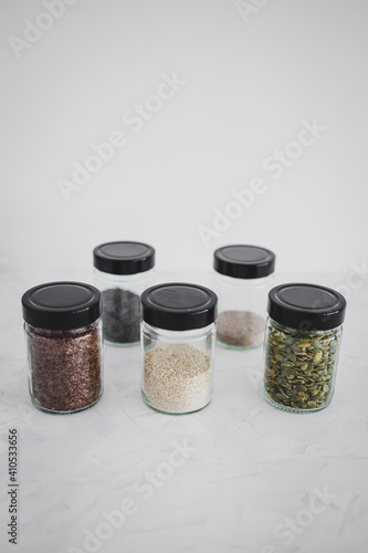 seed jars with sesame poppy pupmkin chia and flax seeds as important nutrient sources for nutrition shot on white background