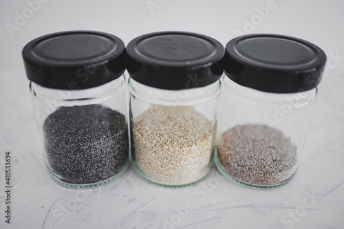 seed jars with sesame poppy pupmkin chia and flax seeds as important nutrient sources for nutrition shot on white background photo