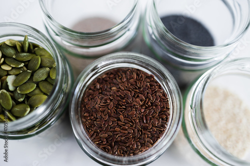 seed jars with sesame poppy pupmkin chia and flax seeds as important nutrient sources for nutrition shot on white background photo