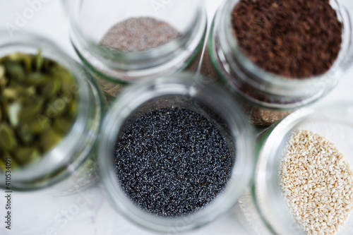 seed jars with sesame poppy pupmkin chia and flax seeds as important nutrient sources for nutrition shot on white background photo