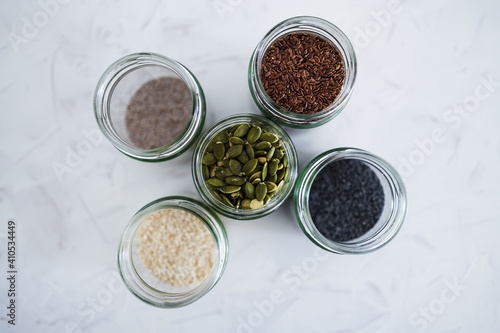 seed jars with sesame poppy pupmkin chia and flax seeds as important nutrient sources for nutrition shot on white background photo