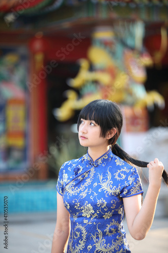 beauty woman wear red cheongsam looking and smile in chinese new year