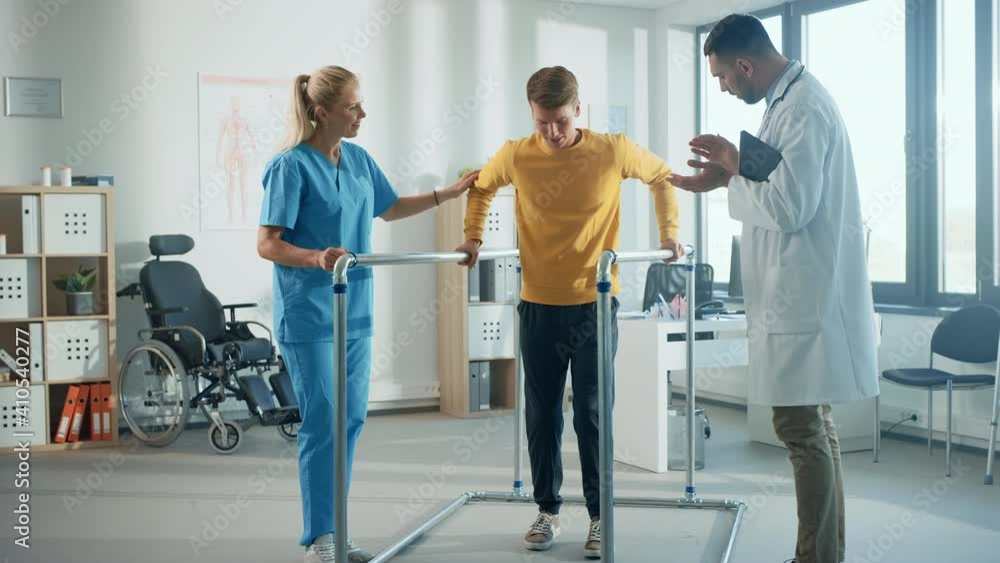 Hospital Physical Therapy: Portrait of Strong Young Male Patient with Injury Successfully Walks Holding Parallel Bars. Physiotherapist, Rehabilitation Doctor, Help, Assist, Disabled Person Hospital Physical Therapy: Portrait of Strong Young Male Patient with Injury Successfully Walks Holding Parallel Bars. Physiotherapist, Rehabilitation Doctor, Help, Assist, Disabled Person