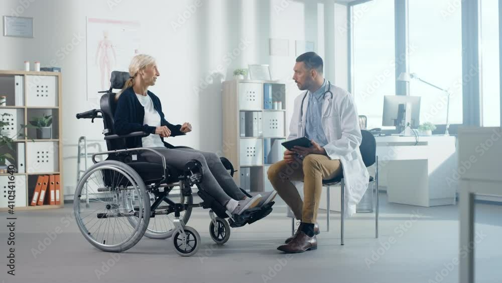 Hospital Physical Therapy: Strong Senior Female in Wheelchair, Talks to a Friendly Rehabilitation Physiotherapist Doctors Gives Advice, Plans Rehabilitation Treatment for Determined Disabled Patient Hospital Physical Therapy: Strong Senior Female in Wheelchair, Talks to a Friendly Rehabilitation Physiotherapist Doctors Gives Advice, Plans Rehabilitation Treatment for Determined Disabled Patient