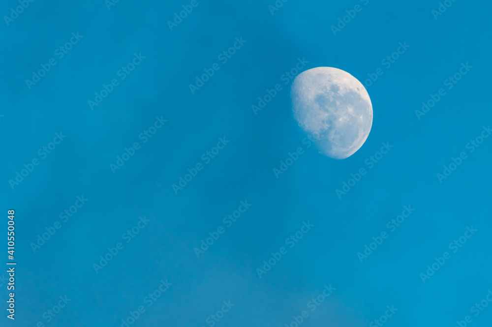 Daytime moon in blue sky with high cloud Daytime moon in blue sky with high cloud