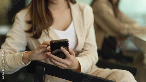 Businesswoman hand using smartphone while sitting in meeting room