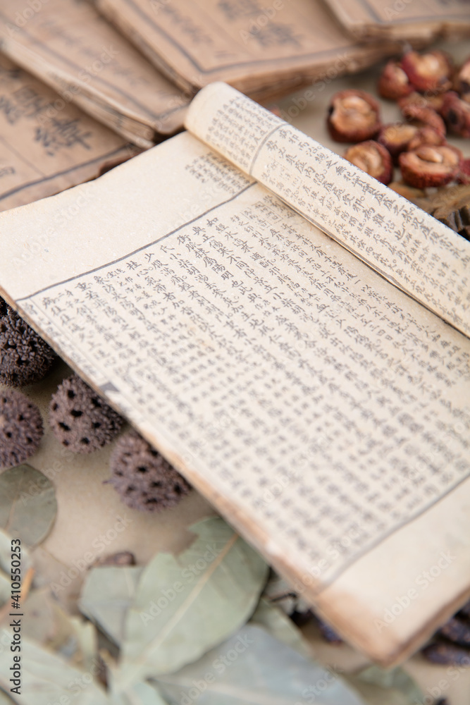 Obraz premium A pile of herbs and an open medicine book