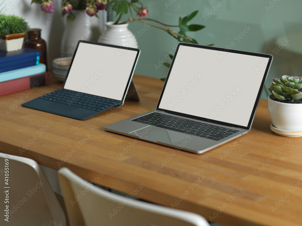 Workspace with laptop, tablet, books and plant pots in home office room Workspace with laptop, tablet, books and plant pots in home office room