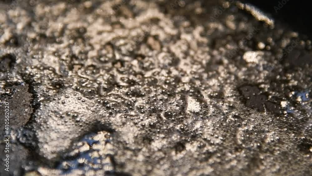 Video of butter, oil sizzling in a pan with black cooking equipment and light shining down on the frypan. Video of butter, oil sizzling in a pan with black cooking equipment and light shining down on the frypan.