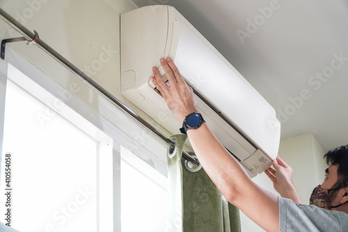Air conditioner technician removes dust filters,technician service removing air filter of the air conditioner for cleaning,Maintenance concept 