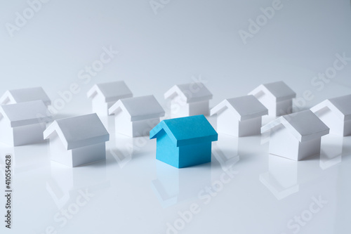 Blue house in among white houses for real estate property industry