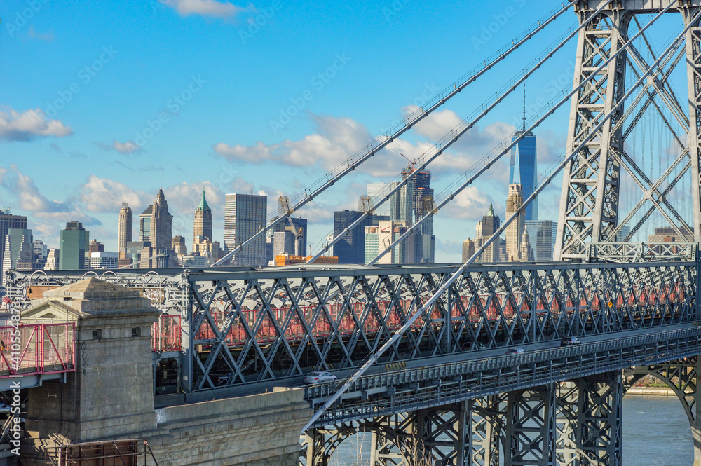 Fototapeta premium Close up bridge shot in Manhattan, NYC, New York City on a beautiful, blue sky day in winter time with sun shining on city landscape in background.